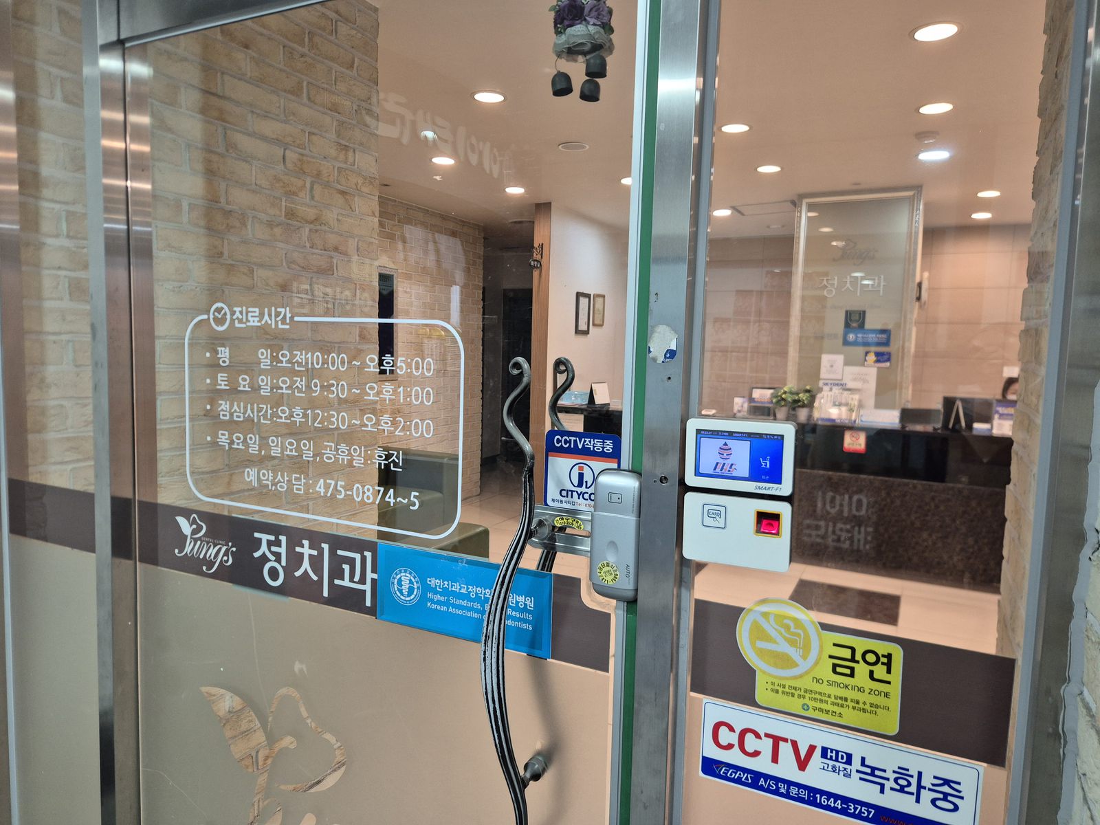 정치과의원 입구 유리문과 진료시간 안내